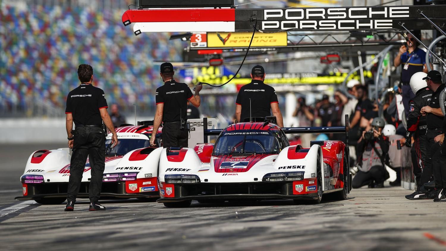 A crew working in the pit lane during a driver change