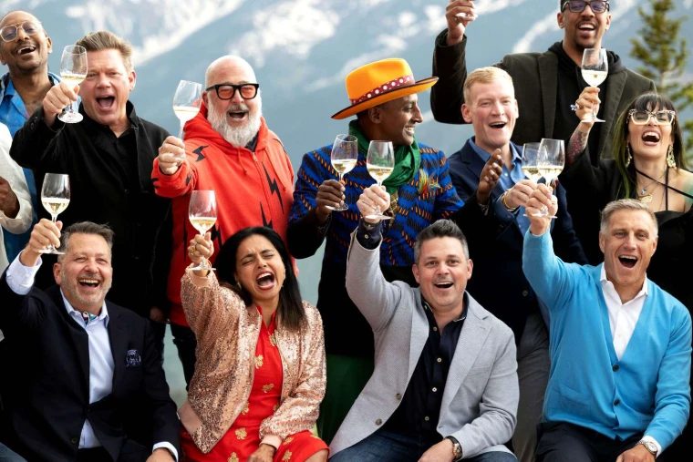 Chefs raising glasses of white wine in a toast against the snow-streaked mountains at the Aspen Food and Wine Classic, an engagement in the season calendar of The Mansa Court