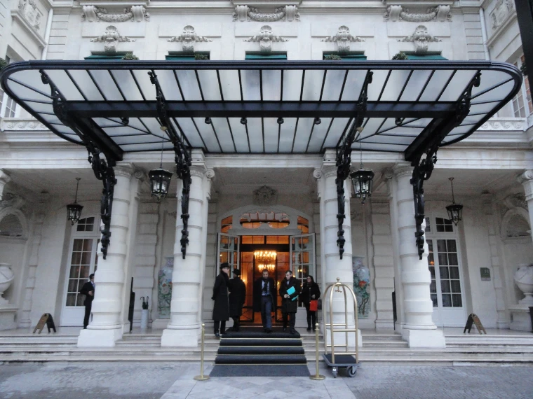 The glass and iron canopy over the columned entrance of the Shangri-La Paris, doormen in long coats on the steps (2014).