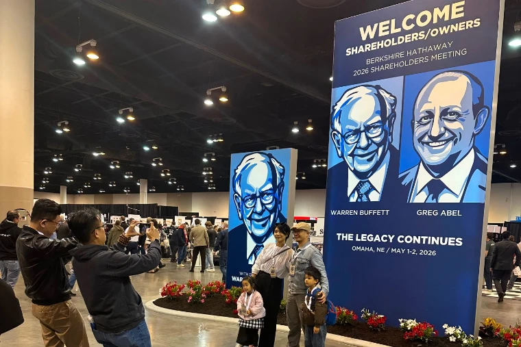 A family poses for a photograph beneath the welcome banner, Omaha, May 1 and 2, 2026. The Berkshire Hathaway Annual Meeting in Omaha, Nebraska, in the season calendar of The Mansa Court