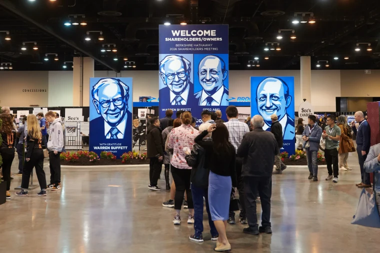 Shareholders gather beneath the tall welcome banners at the entrance to the exhibition hall, in 2026. The Berkshire Hathaway Annual Meeting in Omaha, Nebraska, in the season calendar of The Mansa Court