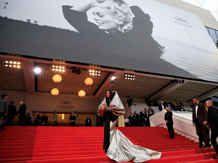 A silver gown on the red steps beneath the festival poster and the lanterns of the Palais (2023). The Cannes Film Festival at the Palais des Festivals, in the season calendar of The Mansa Court