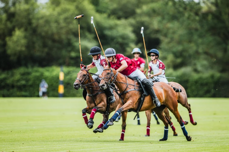 Players ride off shoulder to shoulder at full gallop in a quarter-final (2026). The Cartier Queen’s Cup at Guards Polo Club, Windsor Great Park, in the season calendar of The Mansa Court