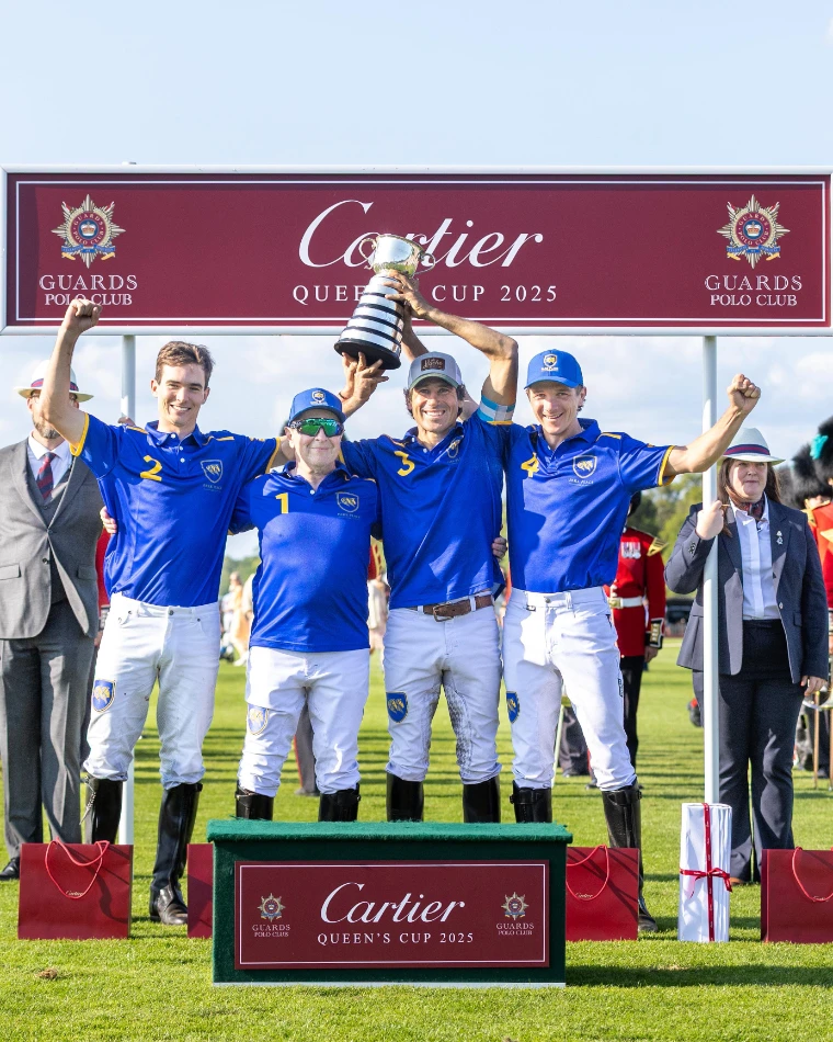 The champions raise the Queen’s Cup on the podium, the Guards band behind them (2025). The Cartier Queen’s Cup at Guards Polo Club, Windsor Great Park, in the season calendar of The Mansa Court