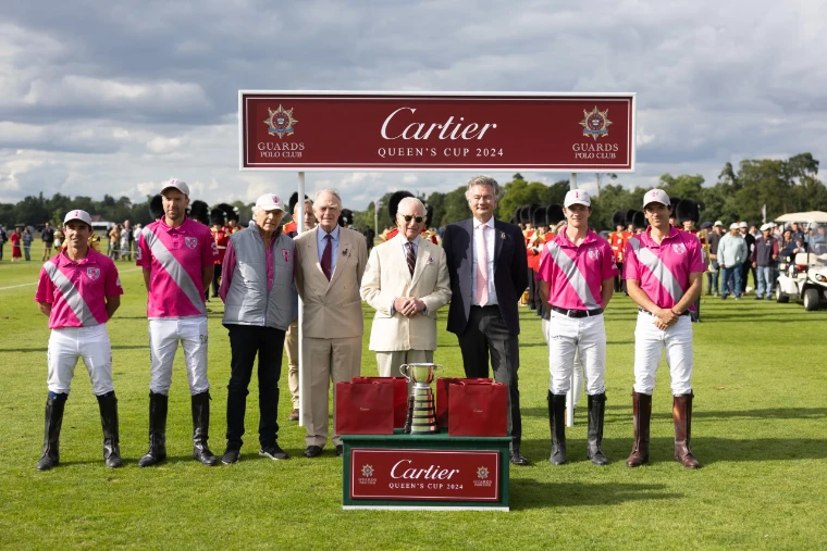The winning team and guests line up behind the Queen’s Cup at the presentation on Smith’s Lawn (2024). The Cartier Queen’s Cup at Guards Polo Club, Windsor Great Park, in the season calendar of The Mansa Court