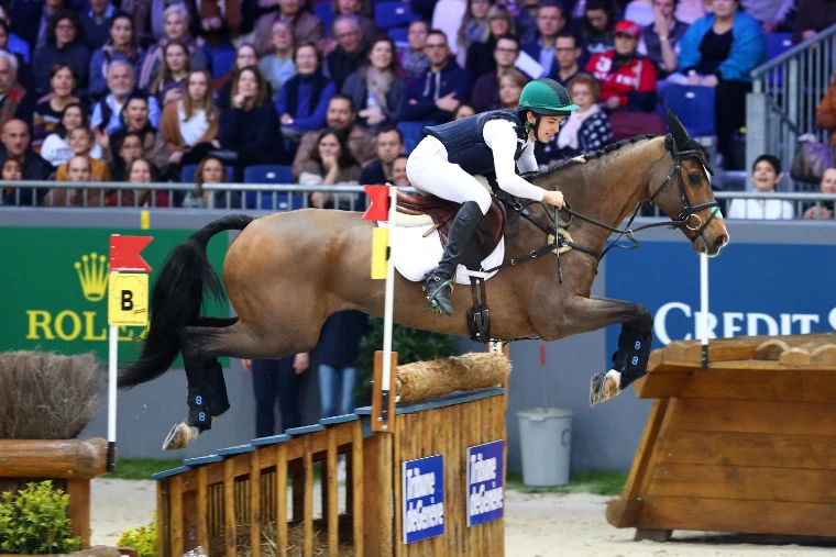 Cathal Daniels on Alcatraz jumping a wooden fence in the indoor cross-country before a crowded stand (2019).