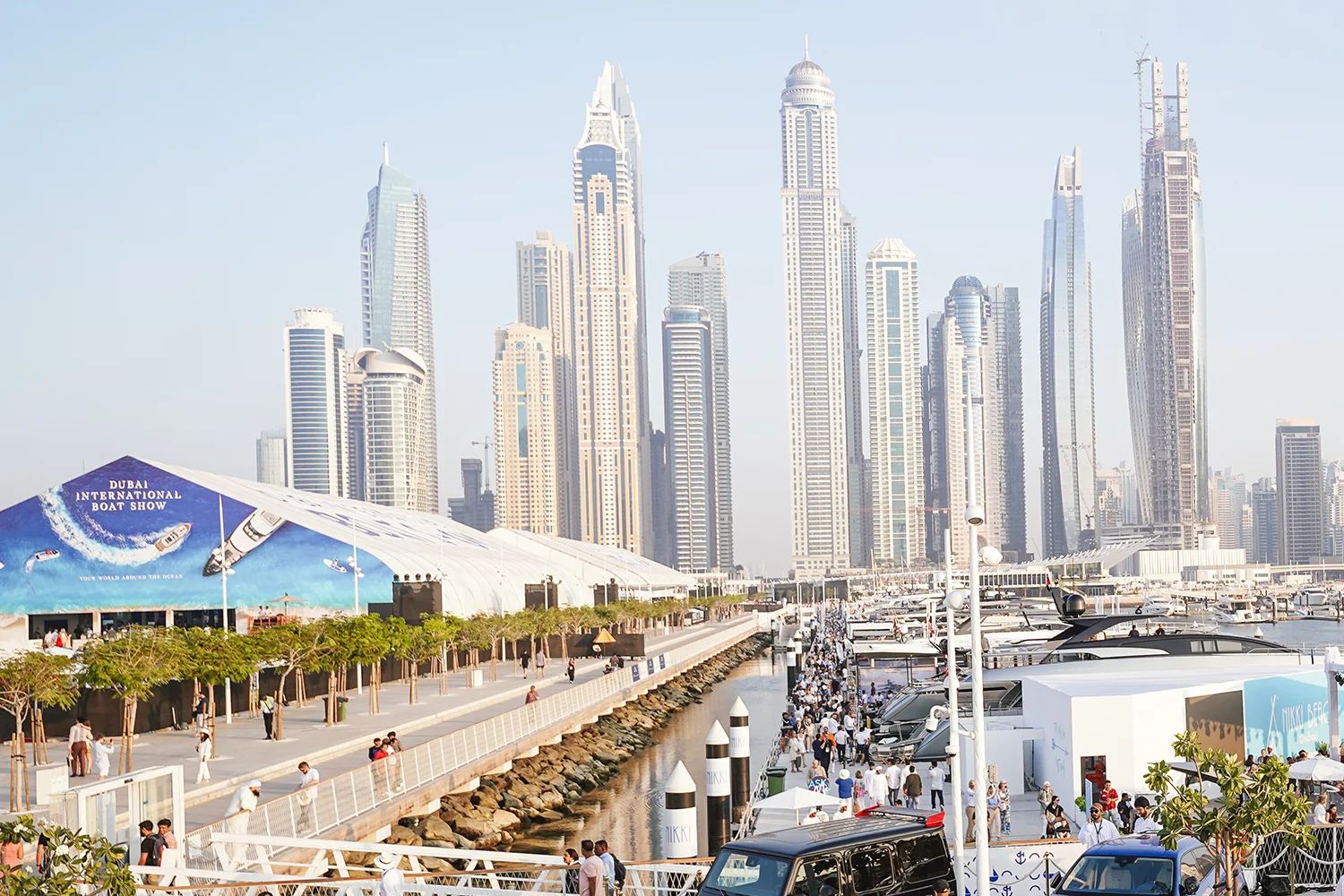 The show halls and berths along the waterfront below the towers of Dubai Marina at the Dubai International Boat Show