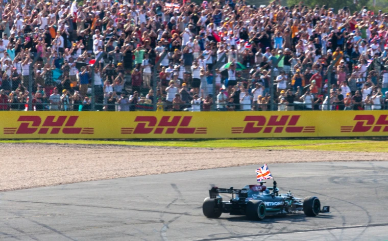 Lewis Hamilton drives past the crowd with a Union flag after winning (2021).