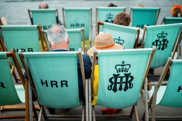 Spectators in the regatta’s pale green deckchairs, marked HRR or with its crowned monogram.