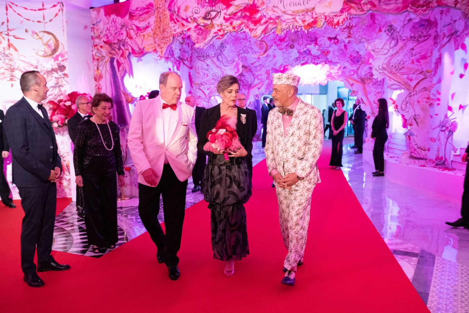 Guests in black tie arriving along the red carpet beneath a painted rose canopy at Le Bal de la Rose, Salle des Étoiles, Monte Carlo