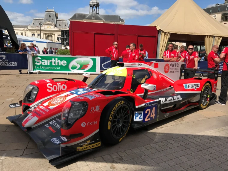 A red prototype on show before its crew in the centre of Le Mans during race week of the 24 Hours, a mid-June engagement in the season calendar of The Mansa Court