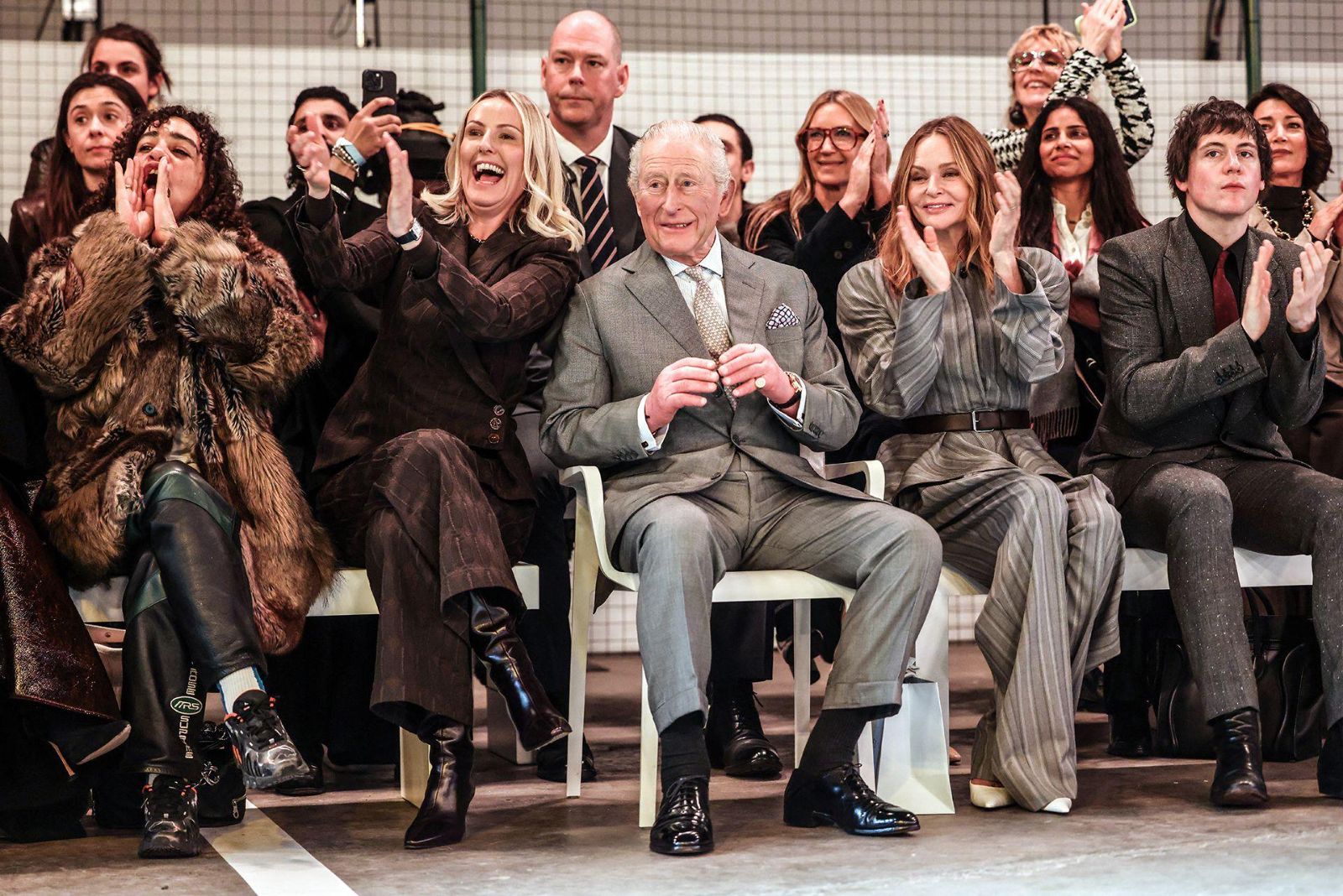 A front row of designers, editors and a royal guest applauding the finale of a London Fashion Week show