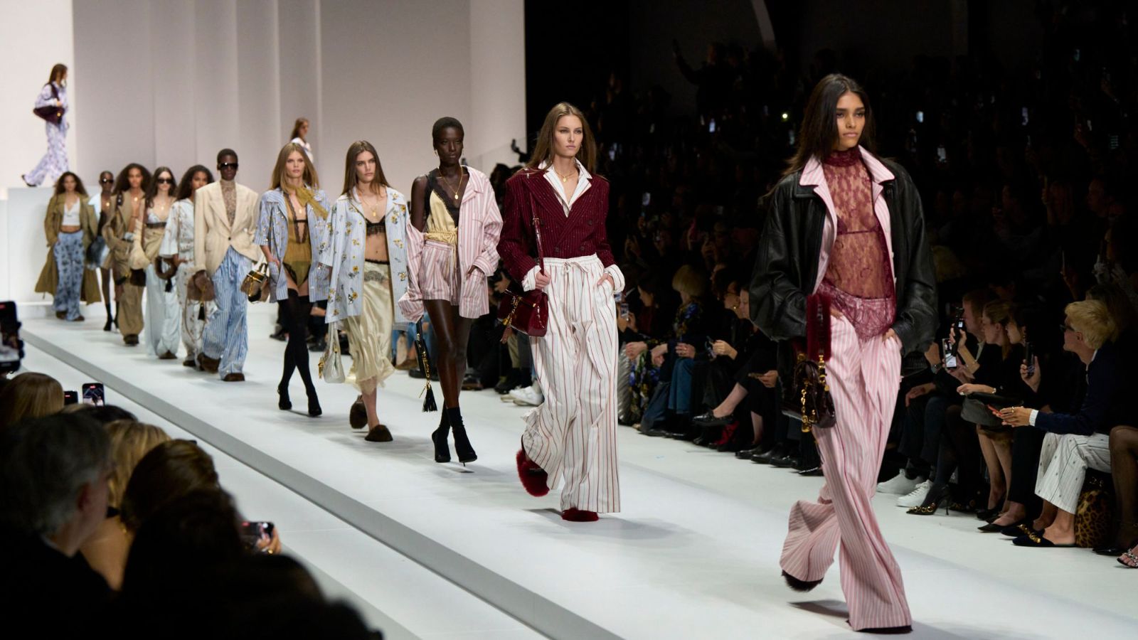 The full cast walking the finale in striped silk pyjama tailoring, lace and leather along a white runway at Milan Fashion Week