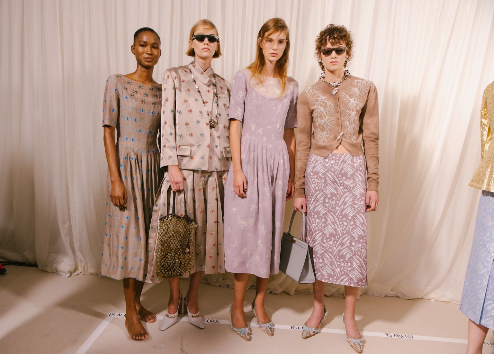 Models standing in look order behind the curtain backstage before a New York Fashion Week show