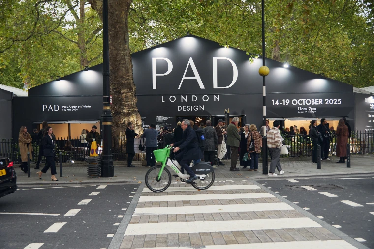 The dark PAD London tent, its gable printed with the fair’s name and October dates, stands beneath plane trees across a Mayfair street as visitors gather outside (2025).