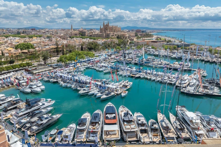 The show harbour crowded with yachts and white pavilions beneath Palma Cathedral and the old town at the Palma International Boat Show, a late-April engagement in the season calendar of The Mansa Court