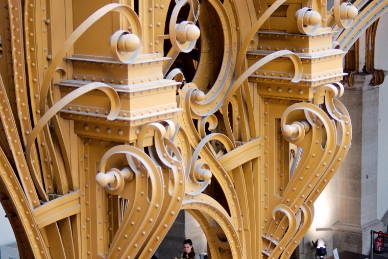 Close view of the painted gold Art Nouveau ironwork of a column in the Grand Palais, its riveted scrolls and volutes, during Paris Photo (2016).