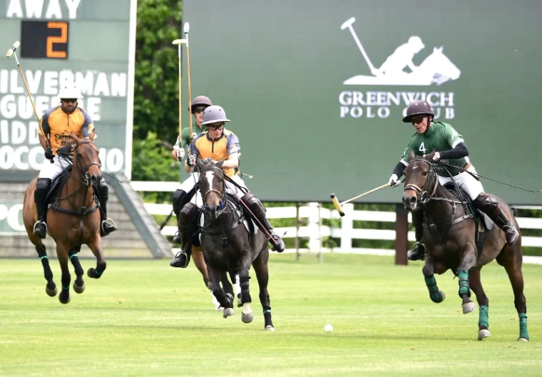 Players galloping after the ball on the field at Greenwich Polo Club, Connecticut, for Polo in Greenwich, a summer afternoon in the season calendar of The Mansa Court