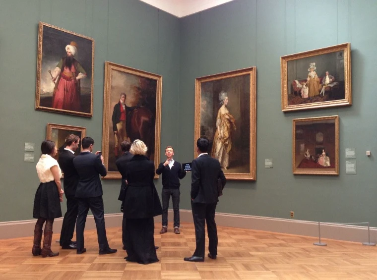 Members gathered with their guide before gilt-framed portraits in an empty museum gallery, a private morning tour hosted by The Mansa Court in New York each April