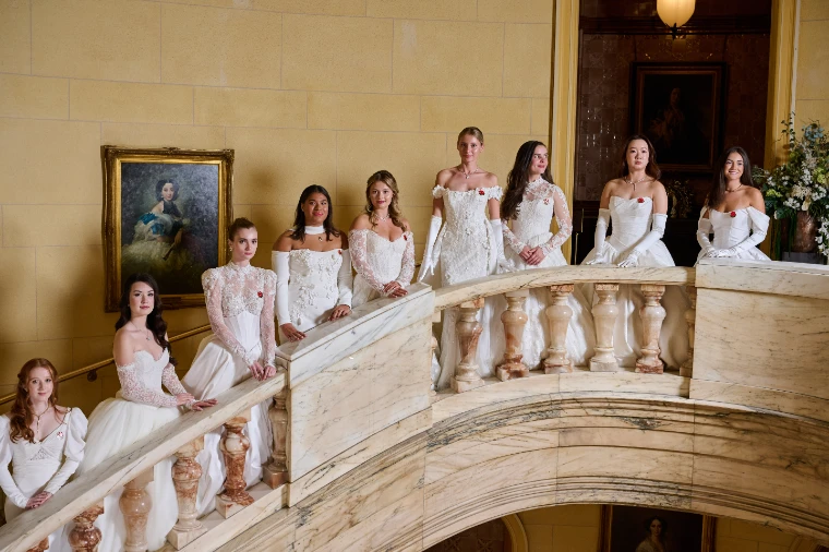 Debutantes in white gowns and long gloves on the marble staircase before the ball. Queen Charlotte’s Ball, One Whitehall Place, London, September 2025, in the season calendar of The Mansa Court