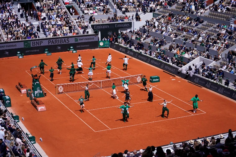 Dancers in green and white fill the court before a final, the stands of Chatrier full around them (2026). The Roland Garros finals on Court Philippe-Chatrier, Paris, in the season calendar of The Mansa Court