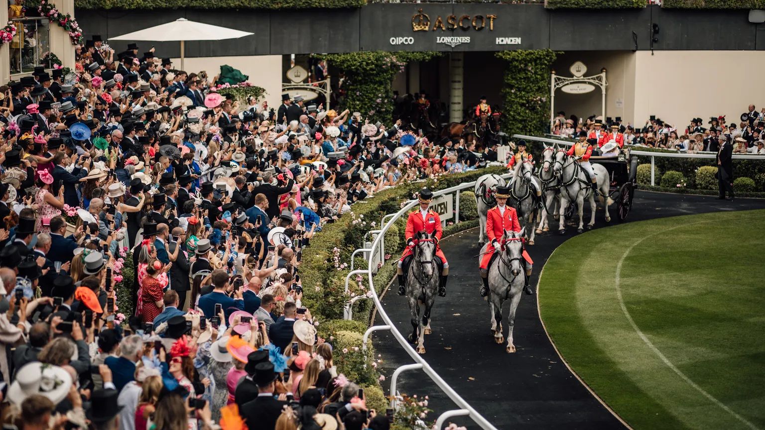 Outriders in scarlet on grey horses leading the Royal Procession into the Parade Ring at Ascot Racecourse