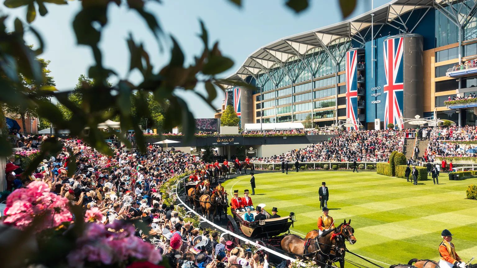 The Royal Procession entering the Parade Ring at Royal Ascot, Union Jack banners on the grandstand