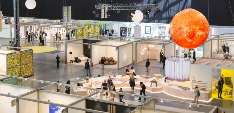 The SaloneSatellite hall of young designers seen from above, beneath a glowing orange sphere, at the Salone del Mobile.Milano 2023, an April engagement in the season calendar of The Mansa Court