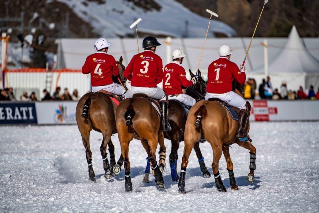 A team riding out onto the snow field at the Snow Polo World Cup