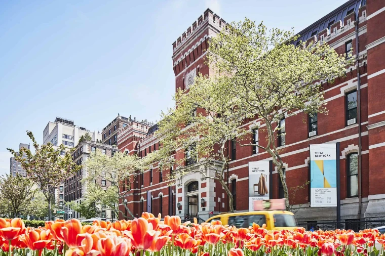 Tulips in bloom on Park Avenue before the red-brick Armory, the fair’s banners on its walls. TEFAF New York at the Park Avenue Armory, in the season calendar of The Mansa Court