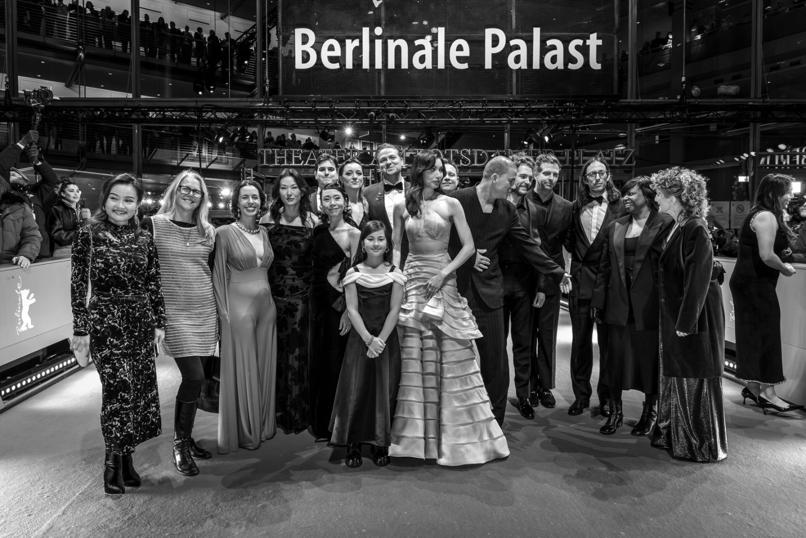 A film’s cast and crew gathered in evening dress for a portrait under the Berlinale Palast sign at The Berlinale