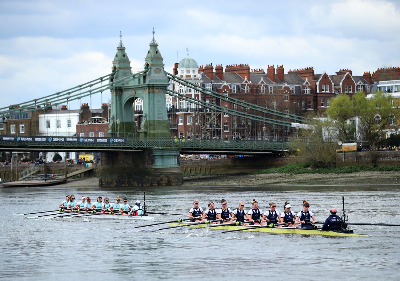 The women’s crews level below Hammersmith Bridge at The Boat Race, Oxford against Cambridge on the Thames, an engagement in The Mansa Court season