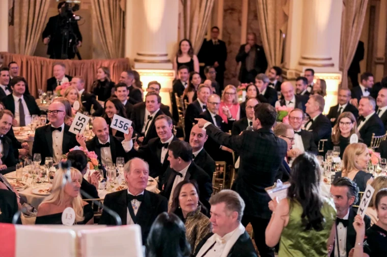 Guests raising numbered paddles to the auctioneer during the charity auction at The British Ball in New York, an April engagement in the season calendar of The Mansa Court