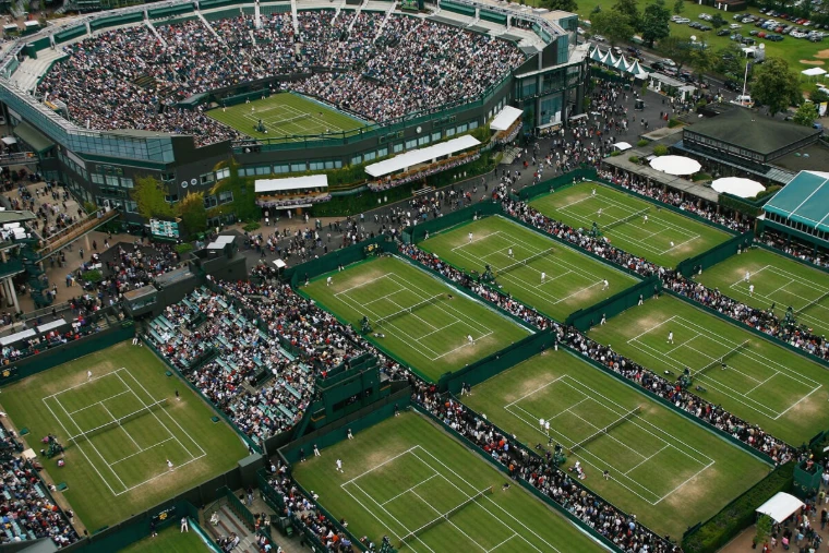 The grass outside courts and Centre Court at the All England Lawn Tennis Club seen from above, crowds between the courts, at The Championships, Wimbledon, London, an early-July engagement in the season calendar of The Mansa Court