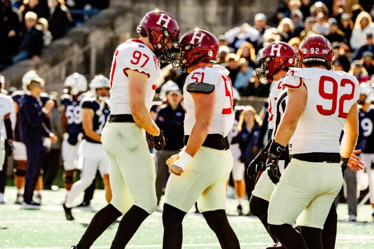 Harvard’s defensive line regroups between plays. The Game, Harvard v Yale, United States, in the season calendar of The Mansa Court