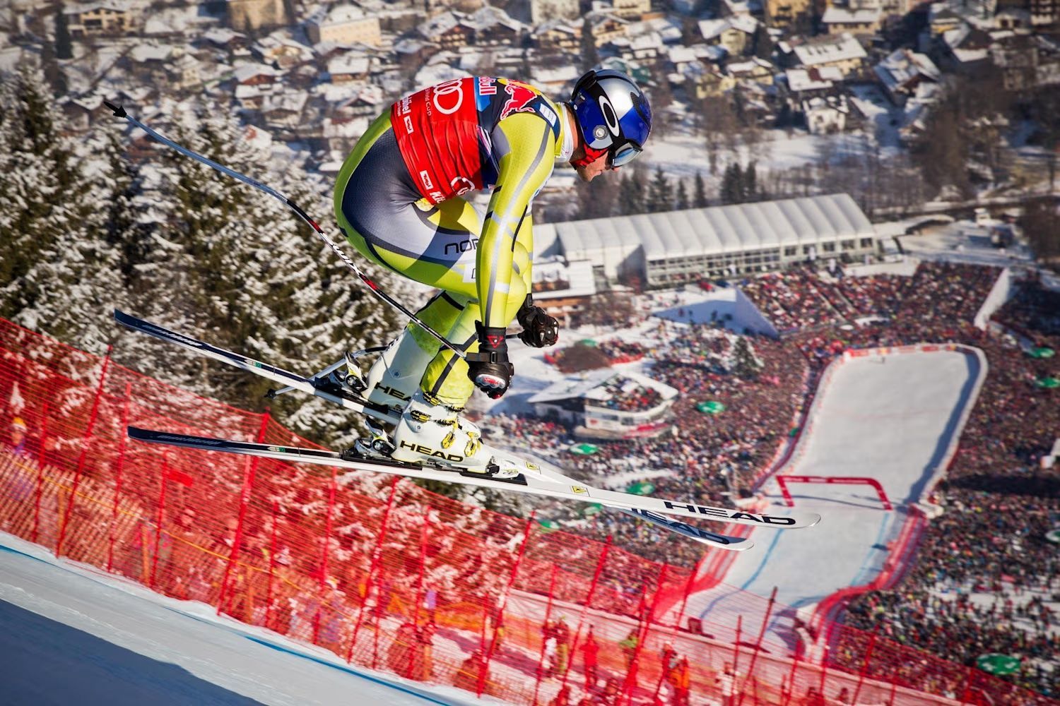 A downhill racer airborne on the Streif above the finish arena at the Hahnenkamm Races