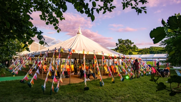 The round marquee hung with bunting beneath a pink evening sky. The Hay Festival at Hay-on-Wye, on the Welsh border, in the season calendar of The Mansa Court