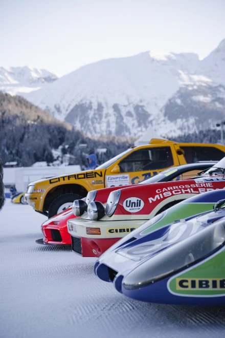 The noses of classic racing cars in their liveries stand in a row on the snow, the mountains behind. The I.C.E. St. Moritz, Lake St. Moritz, St. Moritz, Switzerland, January 2026, in the season calendar of The Mansa Court
