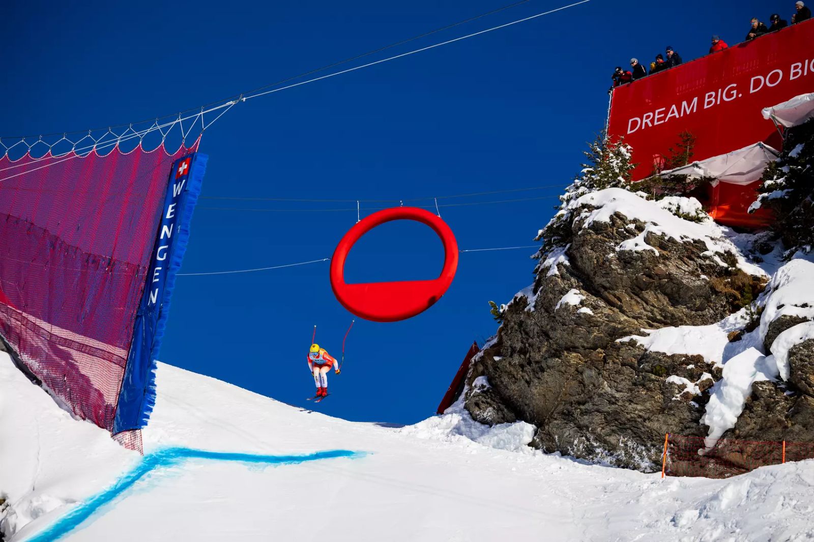 A racer in the air off the Hundschopf jump on the Lauberhorn course