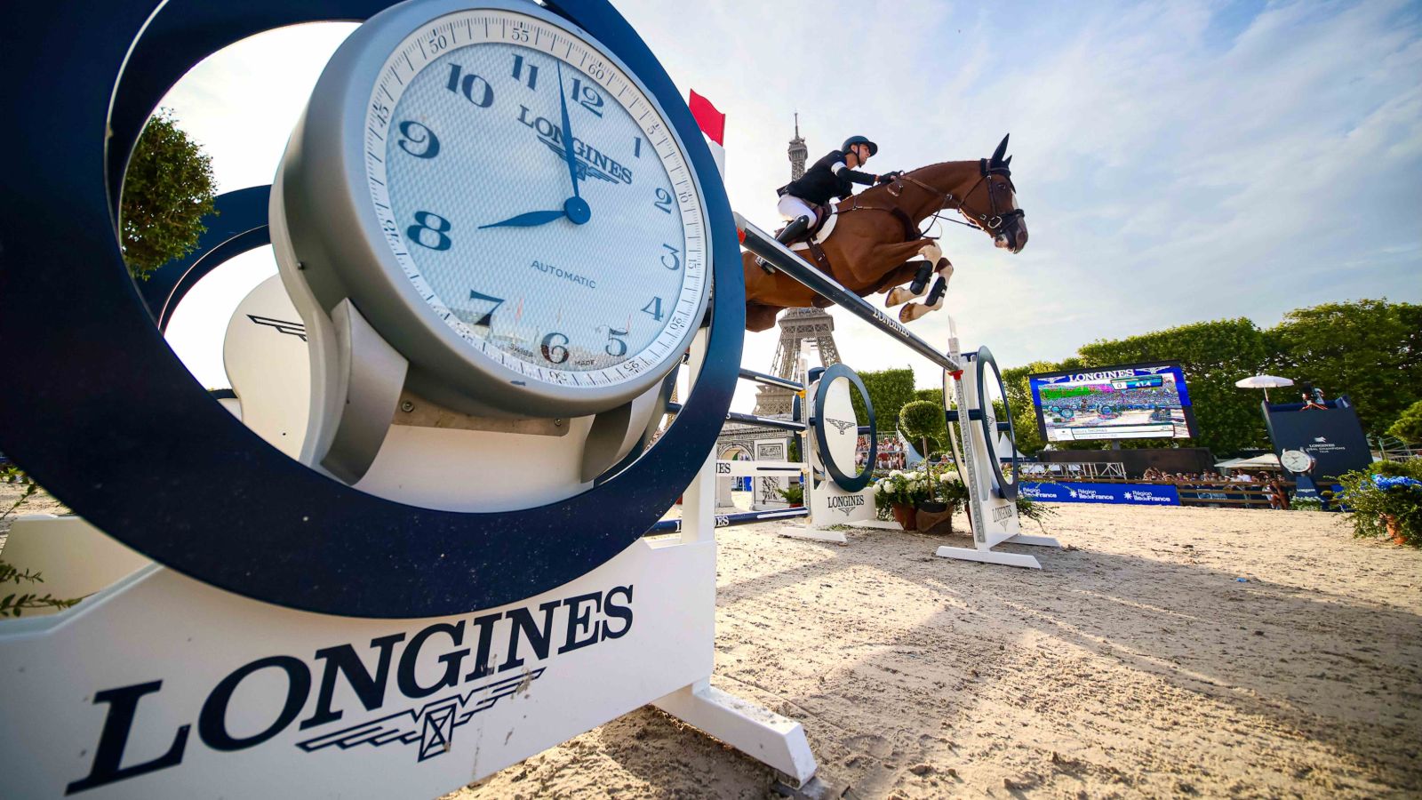 The show jumping arena on the Champ de Mars beneath the Eiffel Tower, flags and full grandstand at the Longines Global Champions Tour, Paris