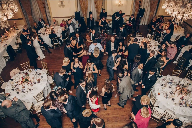 Looking down on the 3 West Club’s ballroom under crystal chandeliers, guests in evening dress dancing between round dinner tables.