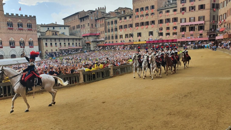 The mounted Carabinieri ride round the Campo, the square filled beyond them (August 2022).