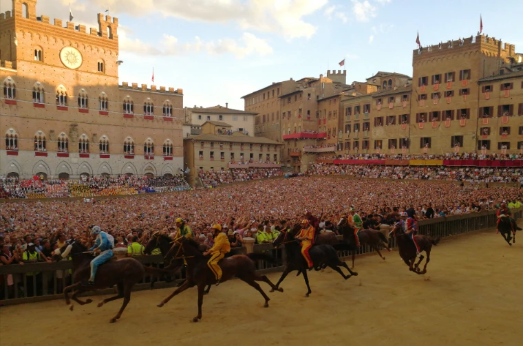 The horses at full gallop round the Campo, the square packed to the rooftops in the evening light (August 2019).