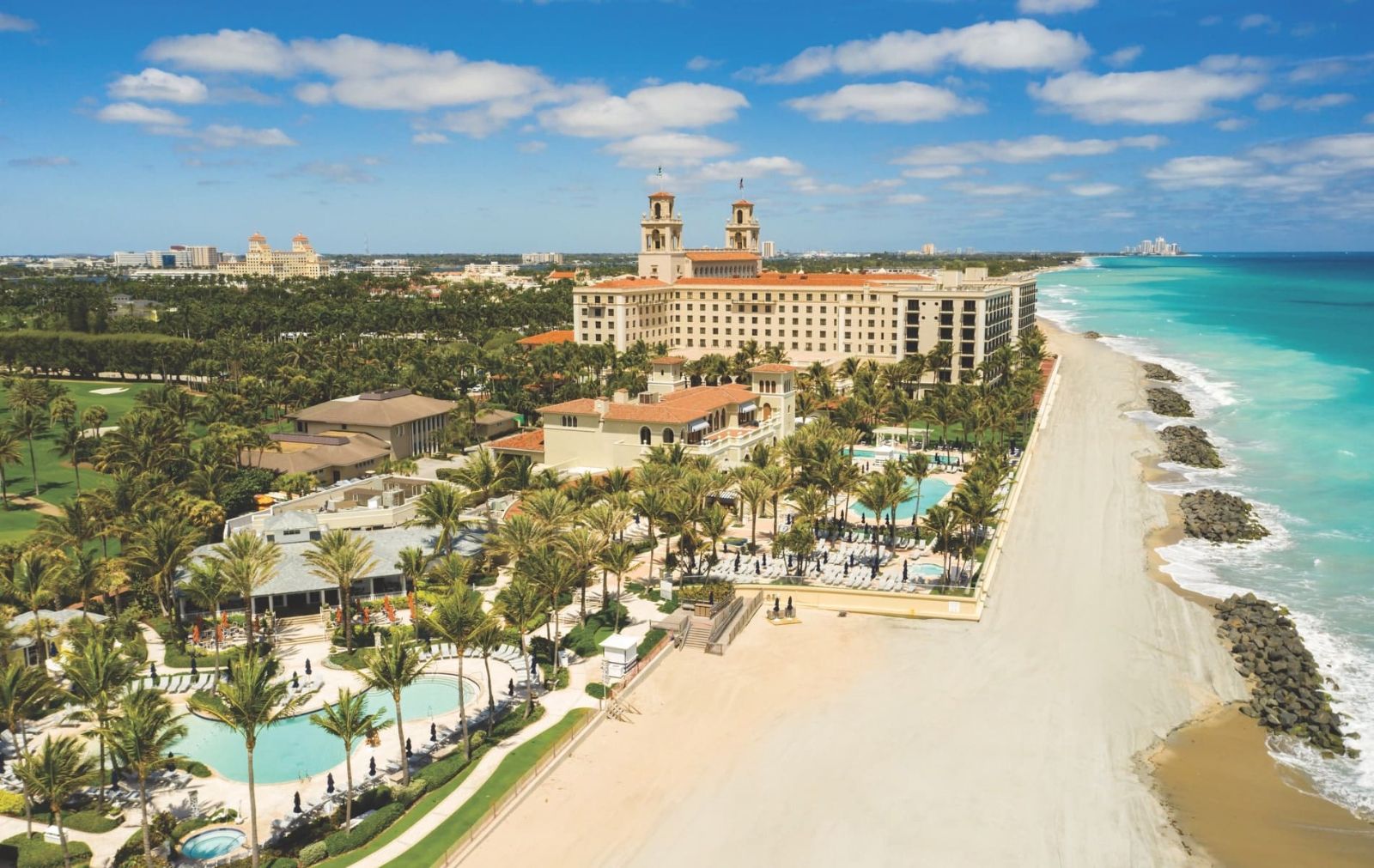 The Palm Beach oceanfront from above, the Atlantic on one side and the island's towers on the other