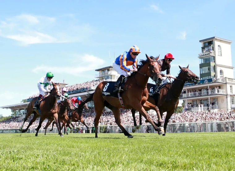 Fillies racing to the line before the packed grandstand and pavilion at the Hippodrome de Chantilly in the Prix de Diane, an engagement in the season calendar of The Mansa Court