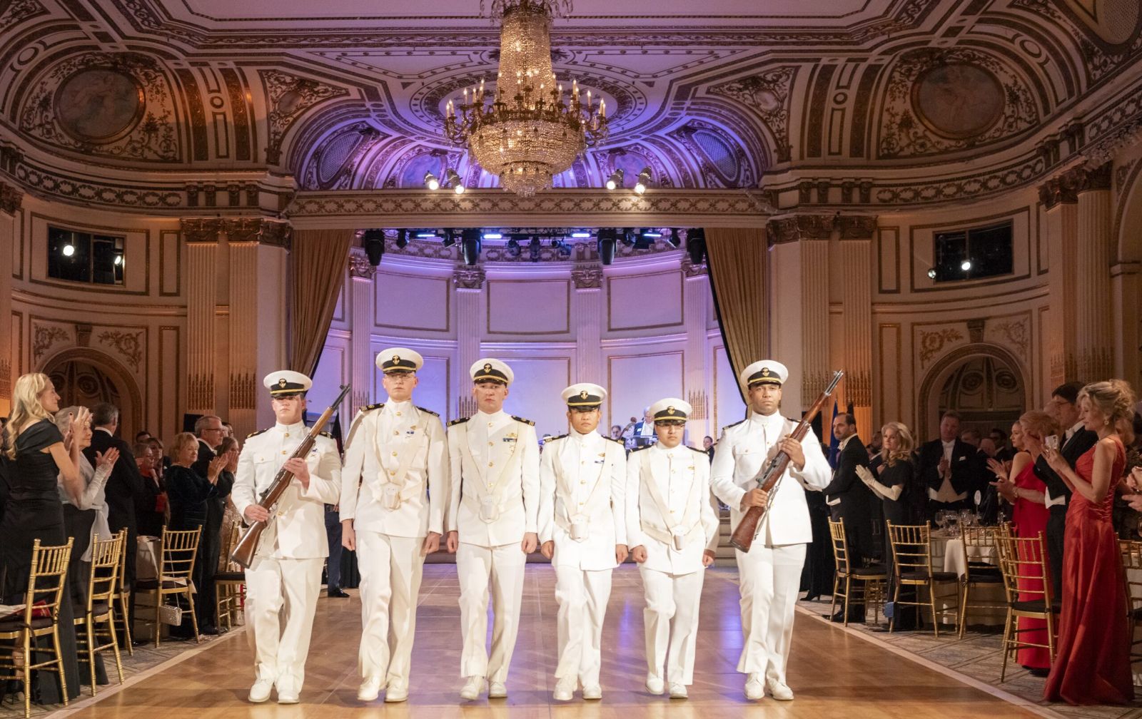 A naval colour guard in dress whites processes the ballroom to open The Quadrille Ball at The Plaza, New York