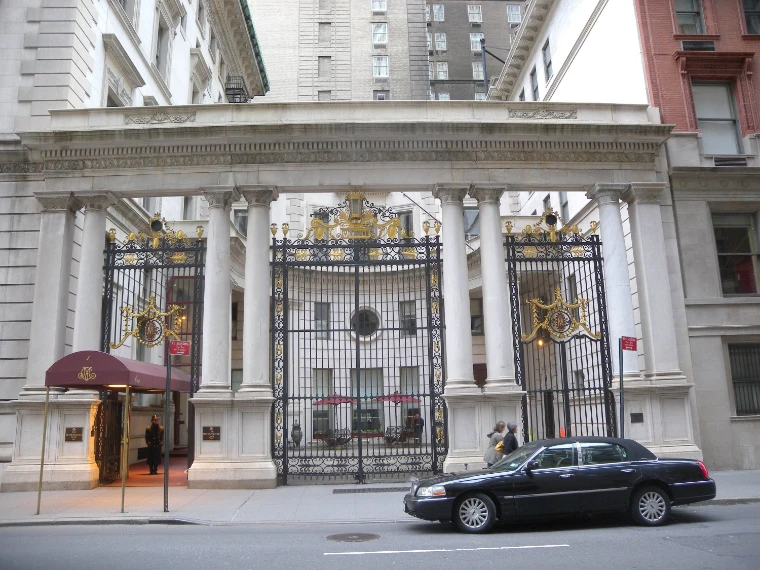 The colonnaded carriage gateway of the Metropolitan Club, its gilded iron gates closed and a maroon awning over the side door (2010).