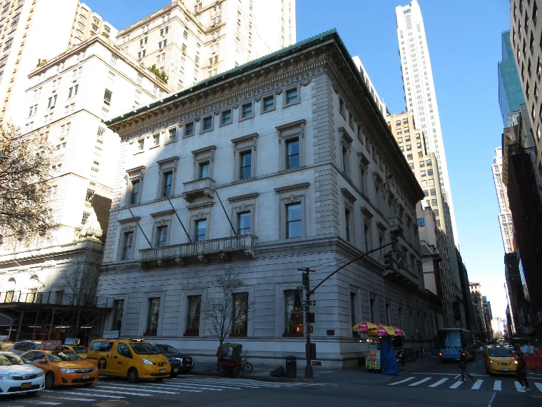 The white marble palazzo of the Metropolitan Club on the corner of Fifth Avenue and East 60th Street, under a clear blue sky (2019).
