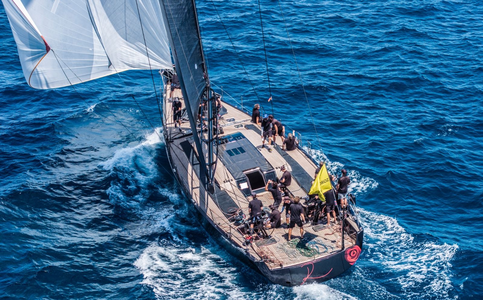 A sailing superyacht seen from above, crew working the afterdeck under way at The Superyacht Challenge, Antigua