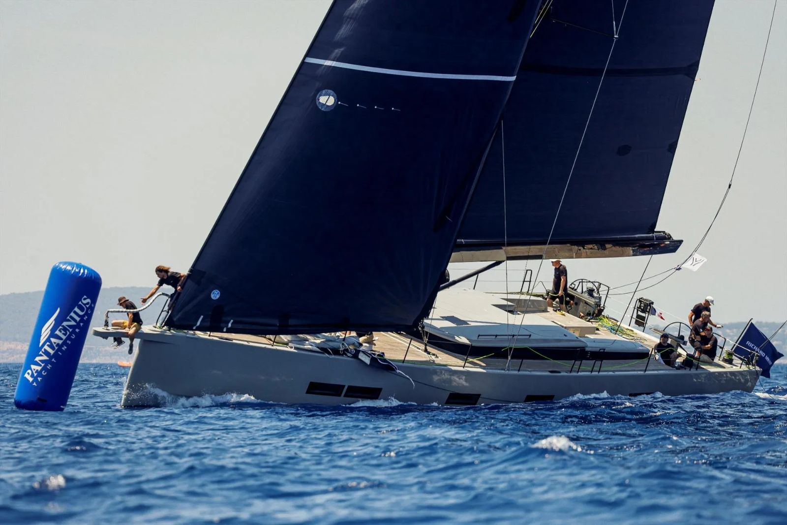 A dark-sailed sloop rounding the mark with crew on the rail at The Superyacht Challenge, the small-fleet regatta off Antigua The Mansa Court keeps each March